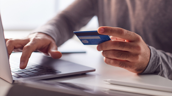 person entering credit card info into computer person entering credit card info into computer
