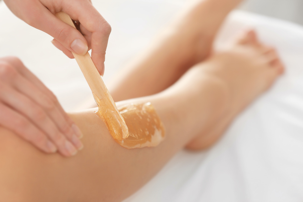 young woman receiving a leg wax